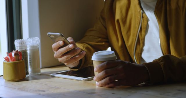 Person Using Smartphone and Drinking Coffee in Cafe - Download Free Stock Images Pikwizard.com