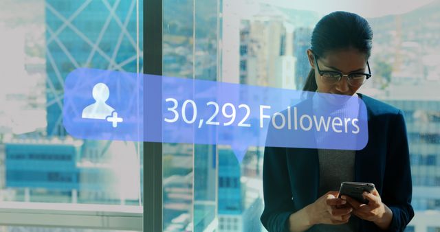 Image of digital interface Followers text and people icon with growing numbers on blue speech bubble over woman using smartphone. Global social media network digitally generated image.