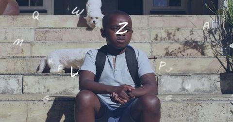 Boy squinting on sunlit front steps with backpack and two small white dogs, porch life