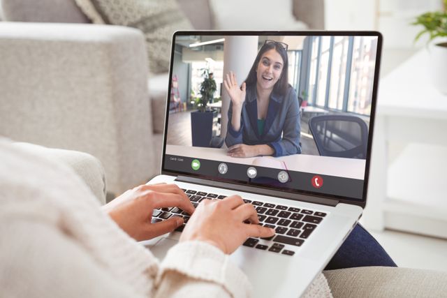 Businesswoman conducting video call with colleague from home office, showing proactive work-from-home setup. Ideal for materials on remote work, communication technology, online meetings, modern work environments, and professional interaction.