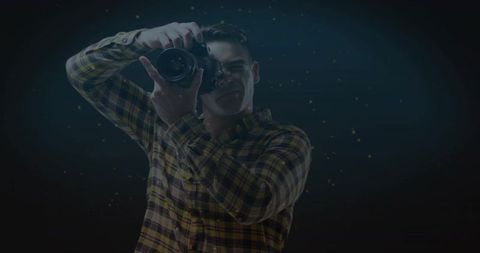 Photographer Framing Shot with DSLR in Yellow Plaid Shirt under Moody Blue Rimlight