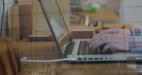Hands typing on laptop keyboard with data transparency overlay