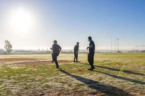 Morning team fitness drill with three athletes jogging between cones at sunrise field