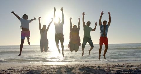 Carefree Friends Enjoying a Leap of Happiness on Sunny Beach - Download Free Stock Images Pikwizard.com