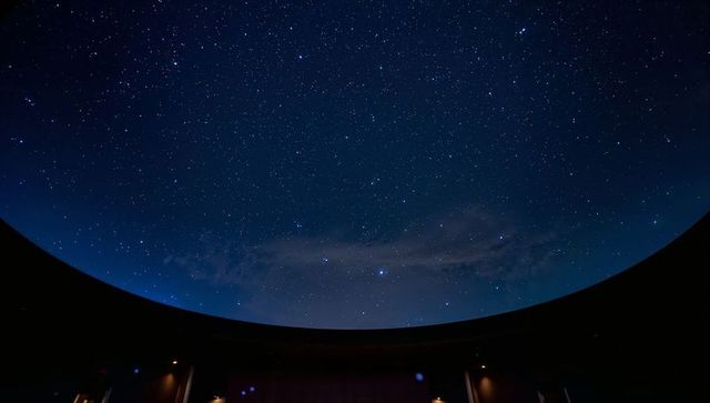Framing star-filled milky way through circular dome aperture with glowing rim silhouette