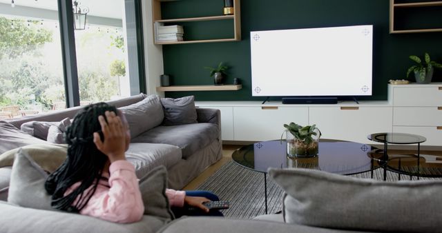 Woman Relaxing on Couch with Remote Control Facing Blank TV Screen - Download Free Stock Images Pikwizard.com