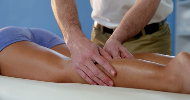 Therapist performing a calf muscle massage on client, emphasizing wellness and relaxation. Useful for promoting spa services, therapy sessions, and professional massage techniques. Ideal for wellness blogs, healthcare brochures, and therapeutic service advertisements.