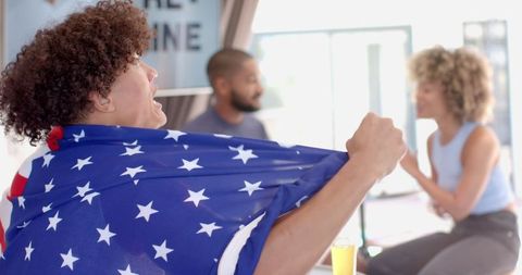 Diverse Friends Cheering and Celebrating with Drinks Indoors