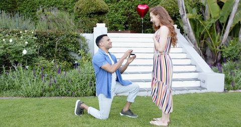 Man Proposing to Woman in Garden with Balloon Background