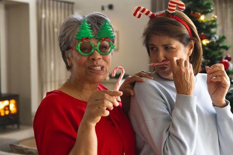 Festive senior friends playing with candy canes during christmas