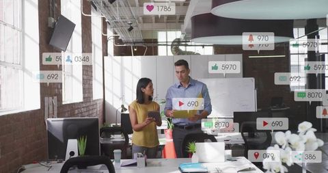 Marketing team analyzing social media engagement metrics in modern open-plan office