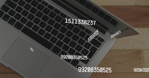 Silver Laptop Displaying Floating Numeric Data Overlays on Wooden Tabletop for AR Visuals