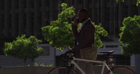 Urban professional businessman talking outdoors with bicycle