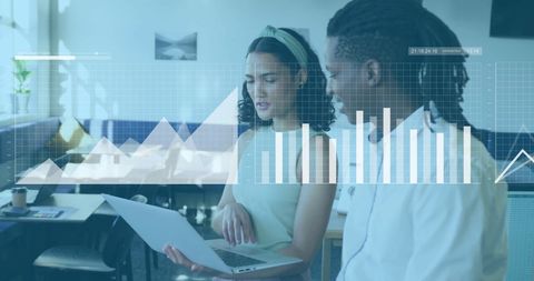 Business Colleagues Analyzing Data on Laptop with Financial Charts Overlay