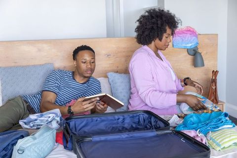 African american couple packing suitcase together preparing for weekend getaway