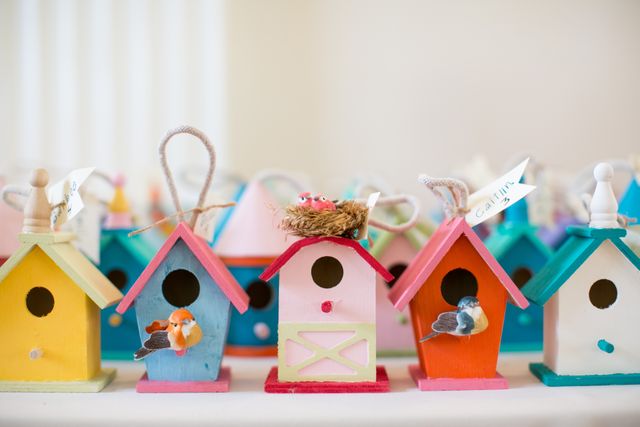 Vibrant birdhouses with decorative birds on wooden surfaces. Perfect for ads about home decor, DIY crafts, and art projects. Can be used in magazines, blogs, or social media platforms showcasing creativity in home projects.