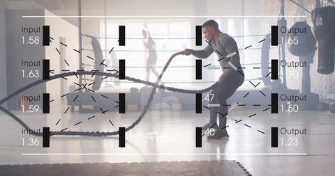 Male athlete swinging battle ropes in industrial gym with data overlay, brick wall, cardio training