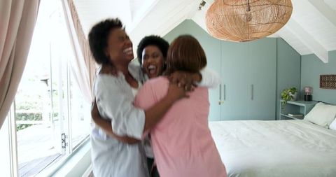 Joyful Reunion: African American Friends Hugging in Bright Bedroom