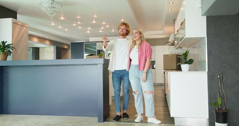 Couple touring modern kitchen discussing home interior