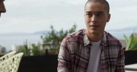Man Relaxing on Roof Terrace Chatting with Friend