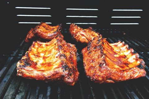 Charred bbq pork ribs grilling on gas grill with sticky glaze and golden bark weekend feast