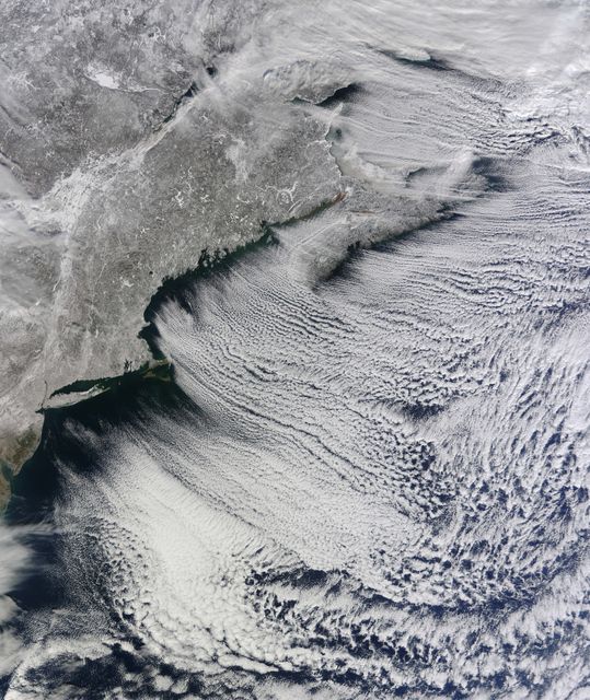 NASA image acquired January 24, 2011  What do you get when you mix below-freezing air temperatures, frigid northwest winds from Canada, and ocean temperatures hovering around 39 to 40 degrees Fahrenheit (4 to 5 degrees Celsius)? Paved highways of clouds across the skies of the North Atlantic.  The Moderate Resolution Imaging Spectroradiometer (MODIS) on NASA’s Terra satellite collected this natural-color view of New England, the Canadian Maritimes, and coastal waters at 10:25 a.m. U.S. Eastern Standard Time on January 24, 2011. Lines of clouds stretch from northwest to southeast over the North Atlantic, while the relatively cloudless skies over land afford a peek at the snow that blanketed the Northeast just a few days earlier.  Cloud streets form when cold air blows over warmer waters, while a warmer air layer—or temperature inversion—rests over top of both. The comparatively warm water of the ocean gives up heat and moisture to the cold air mass above, and columns of heated air—thermals—naturally rise through the atmosphere. As they hit the temperature inversion like a lid, the air rolls over like the circulation in a pot of boiling water. The water in the warm air cools and condenses into flat-bottomed, fluffy-topped cumulus clouds that line up parallel to the wind.  Though they are easy to explain in a broad sense, cloud streets have a lot of mysteries on the micro scale. A NASA-funded researcher from the University of Wisconsin recently observed an unusual pattern in cloud streets over the Great Lakes. Cloud droplets that should have picked up moisture from the atmosphere and grown in size were instead shrinking as they moved over Lake Superior. Read more in an interview at What on Earth?  NASA image by Jeff Schmaltz, MODIS Rapid Response Team, Goddard Space Flight Center. Caption by Michael Carlowicz.  Instrument: Terra - MODIS  Credit: <b><a href="http://www.earthobservatory.nasa.gov/" rel="nofollow"> NASA Earth Observatory</a></b>  <b><a href="http://www.nasa.gov/centers/goddard/home/index.html" rel="nofollow">NASA Goddard Space Flight Center</a></b> enables NASA’s mission through four scientific endeavors: Earth Science, Heliophysics, Solar System Exploration, and Astrophysics. Goddard plays a leading role in NASA’s accomplishments by contributing compelling scientific knowledge to advance the Agency’s mission.  <b>Follow us on <a href="http://twitter.com/NASA_GoddardPix" rel="nofollow">Twitter</a></b>  <b>Join us on <a href="http://www.facebook.com/pages/Greenbelt-MD/NASA-Goddard/395013845897?ref=tsd" rel="nofollow">Facebook</a></b>