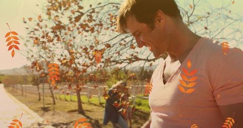 Happy Family Enjoying Autumn Sunny Day Among Falling Leaves