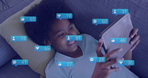 Teen Girl Engaged With Social Media on Tablet Lying on Sofa