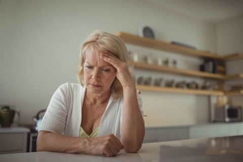 Senior Woman Contemplating at Kitchen Island