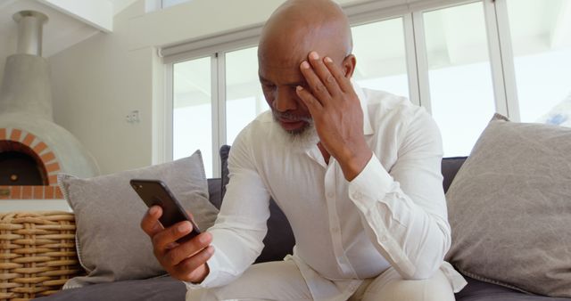 Older man stressed looking at smartphone at home - Download Free Stock Images Pikwizard.com