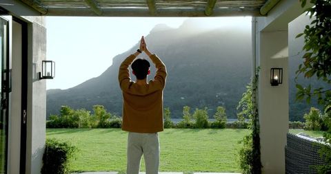 Man Outdoors Checking Smartwatch Overlooking Scenic Mountain Sunrise