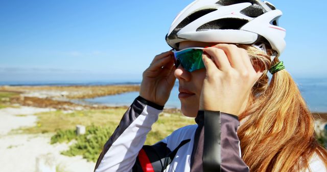 Caucasian female cyclist adjusting sunglasses during outdoor ride - Download Free Stock Images Pikwizard.com