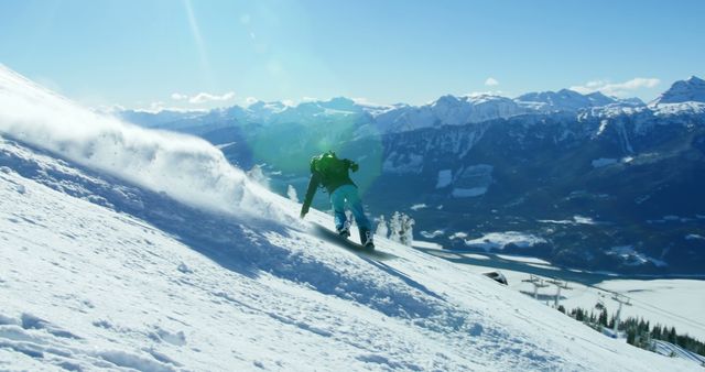 A snowboarder carves through fresh powder on a mountain slope, with copy space. Dressed in a bright green jacket, the athlete enjoys a clear day with stunning mountain views in the background.