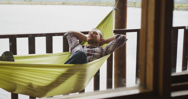 Man Relaxing in Hammock on Waterfront Porch - Download Free Stock Images Pikwizard.com