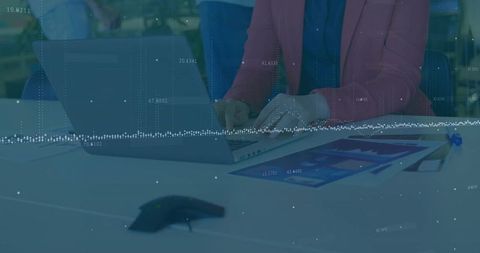 Business professional typing on laptop with digital analytics overlay
