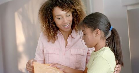 Mother and Daughter Sorting Recycling Together at Home