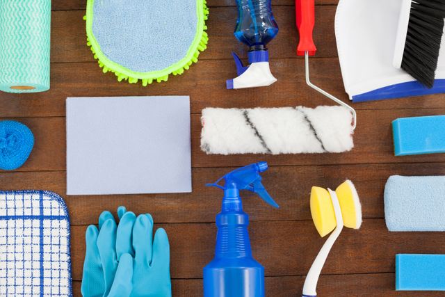 Close-up of various cleaning equipment arranged on wooden floor