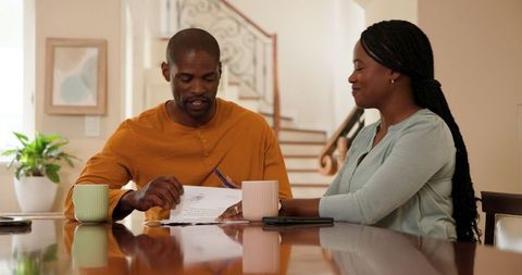 Smiling couple discussing finances at home table