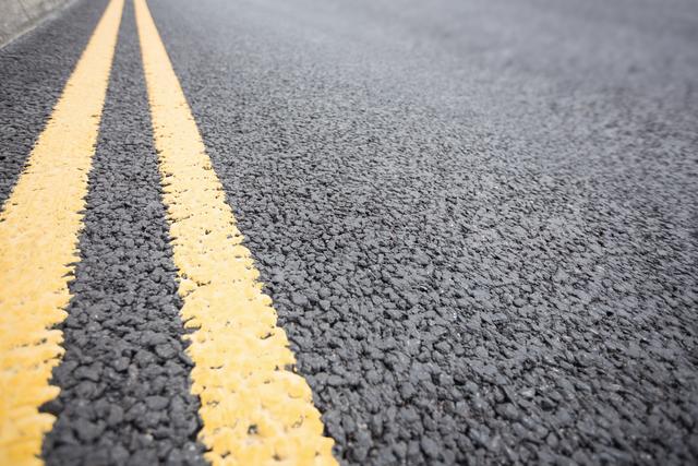 Yellow road marking on road surface, full frame