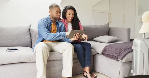 Couple Using Tablet Preparing for Vacation Together