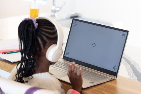African american child wearing headphones using laptop for remote learning