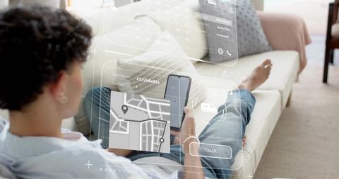 Young man lounging on sofa tracking package with augmented reality map on smartphone and tablet