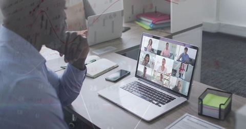 Watching Remote Team Video Conference on Laptop at Office Desk for Hybrid Collaboration