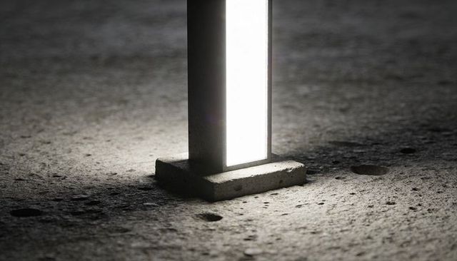Glowing Rectangular Pillar Casting Light on Textured Concrete Floor Minimalist Industrial