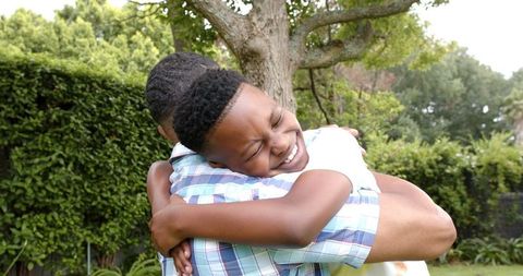 Joyful African American Father and Son Embrace Outdoors