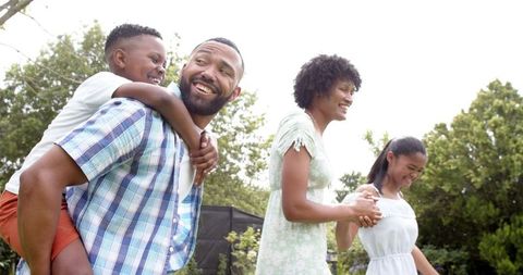 Happy Family Strolling in Sunny Garden Joyously Bonding