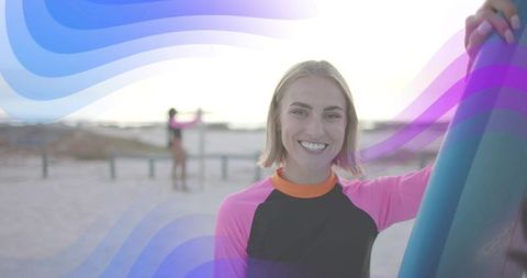 Smiling Surfer in Wetsuit Holding Surfboard on Sandy Beach