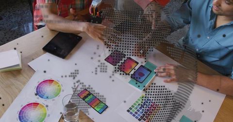 Creative team collaborating on mobile mockups, reviewing palettes, gradients and halftone