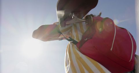 Skater Holding Skateboard with Backpack in Sunshine