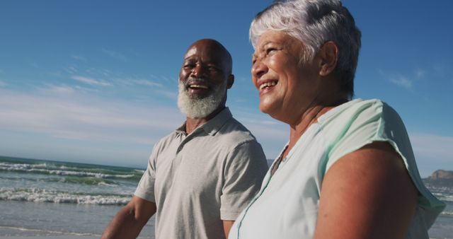 Elderly couple enjoying time together on the beach. Great for advertisements related to retirement, travel, healthy living, and senior lifestyle promotions.